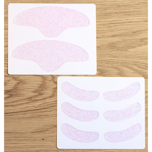 Picture of Busy Signal patches sitting on insert cards on a wooden table, showing two Forehead patches and six Eye & Smile patches 